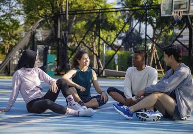 Menschen sitzen auf Sportplatz